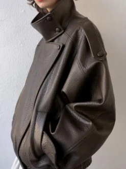 Veste bomber vintage en similicuir noir et marron uni coupe décontractée taille élastiquée.